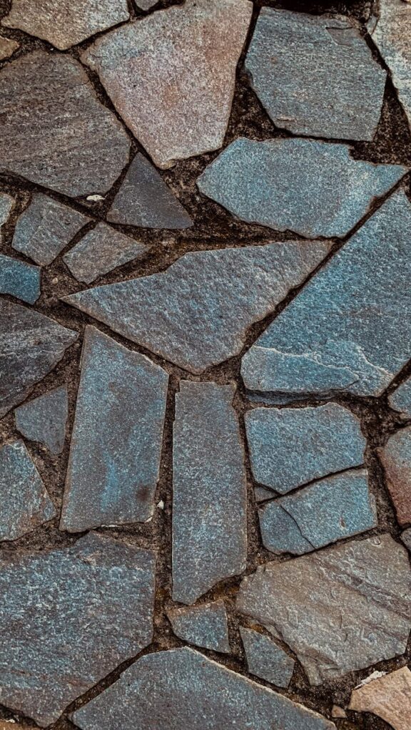 Detailed close-up of irregular stone pavement with distinct textures and colors.
